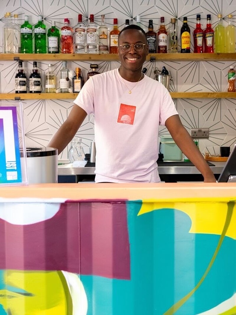 colourful popup bar and bartender in the exterior yard of Runway East London bridge.
