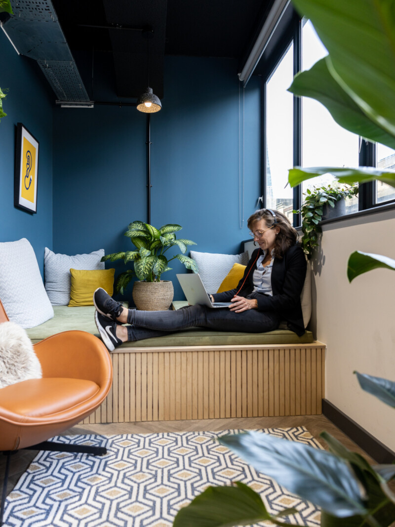 person working on day bed in cosy breakout corner of runway east london bridge