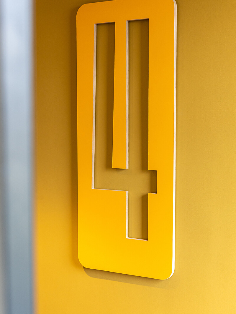 Yellow wayfinding sign at Runway East London Bridge