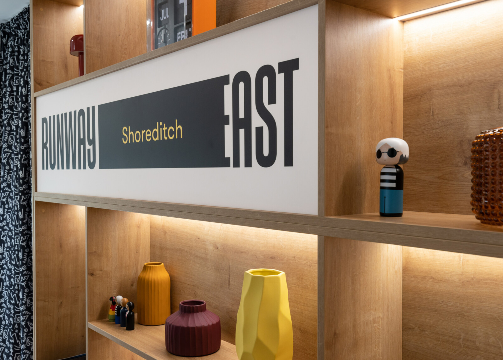 Signage and dressing accessories on shelving at Runway East Shoreditch