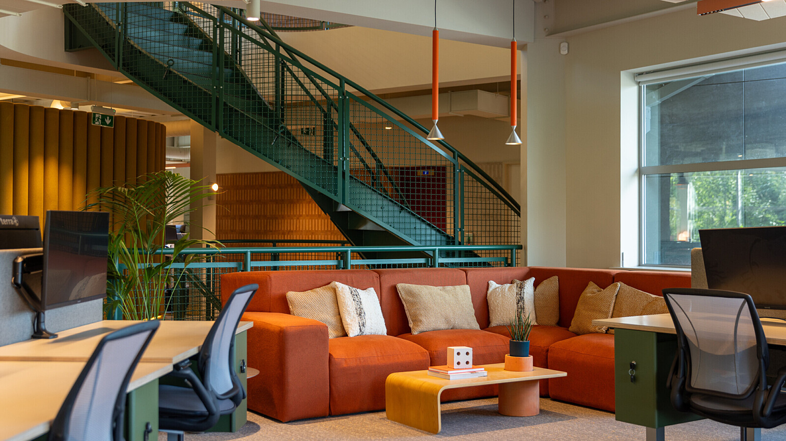 Breakout sofa and green open staircase for TMT Group HQ workspace