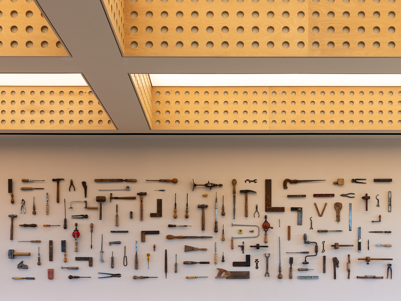 Wall art made from recycled construction tools at TMT group HQ workspace