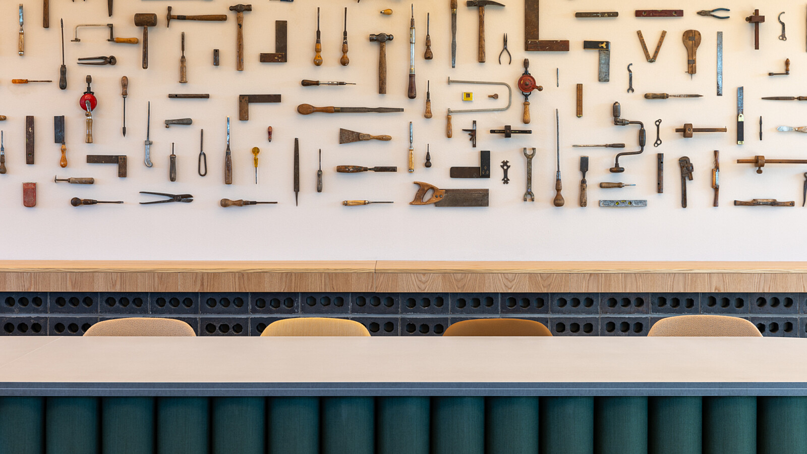 Wall art made from reclaimed construction tools in the board room of TMT Group HQ workspace