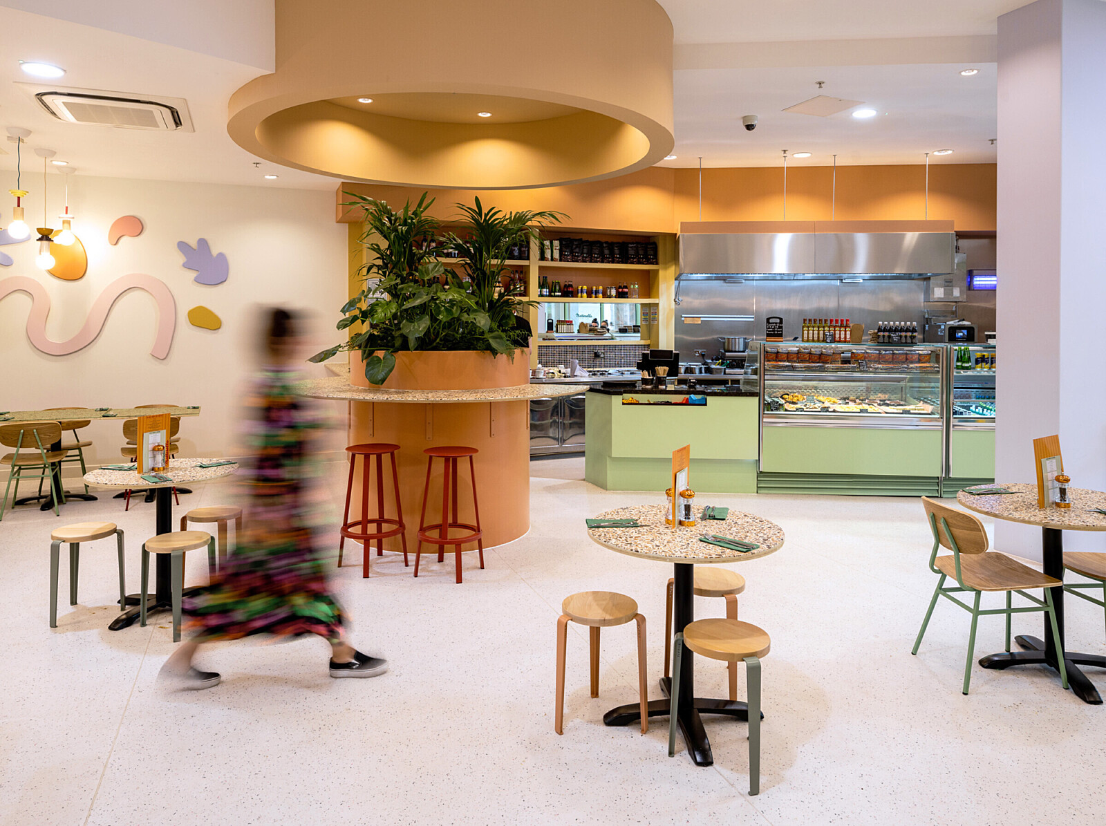 Wide view of Matterello interior with wall artwork, planter seating and open servery